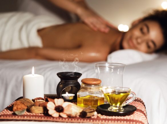 African woman enjoying aromatherapy massage in luxury spa