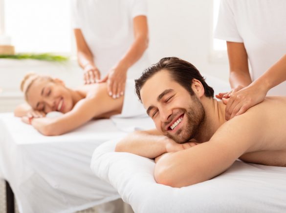 Husband And Wife Enjoying Relaxing Couples Massage At Spa Salon